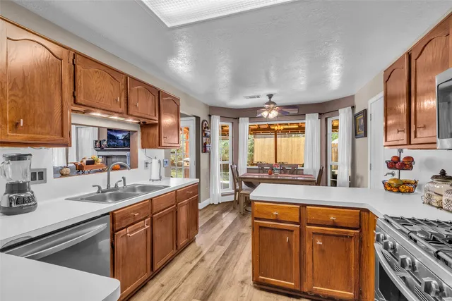 a kitchen with stainless steel appliances granite countertop a sink stove and cabinets