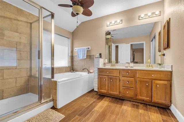 a spacious bathroom with a tub sink and mirror