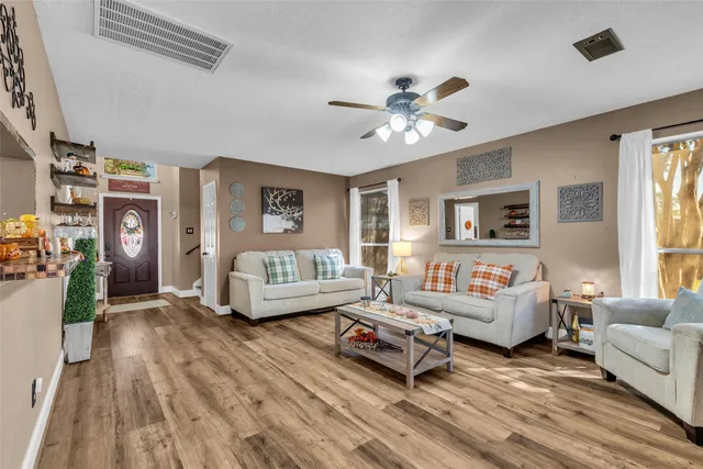 a living room with furniture and wooden floor