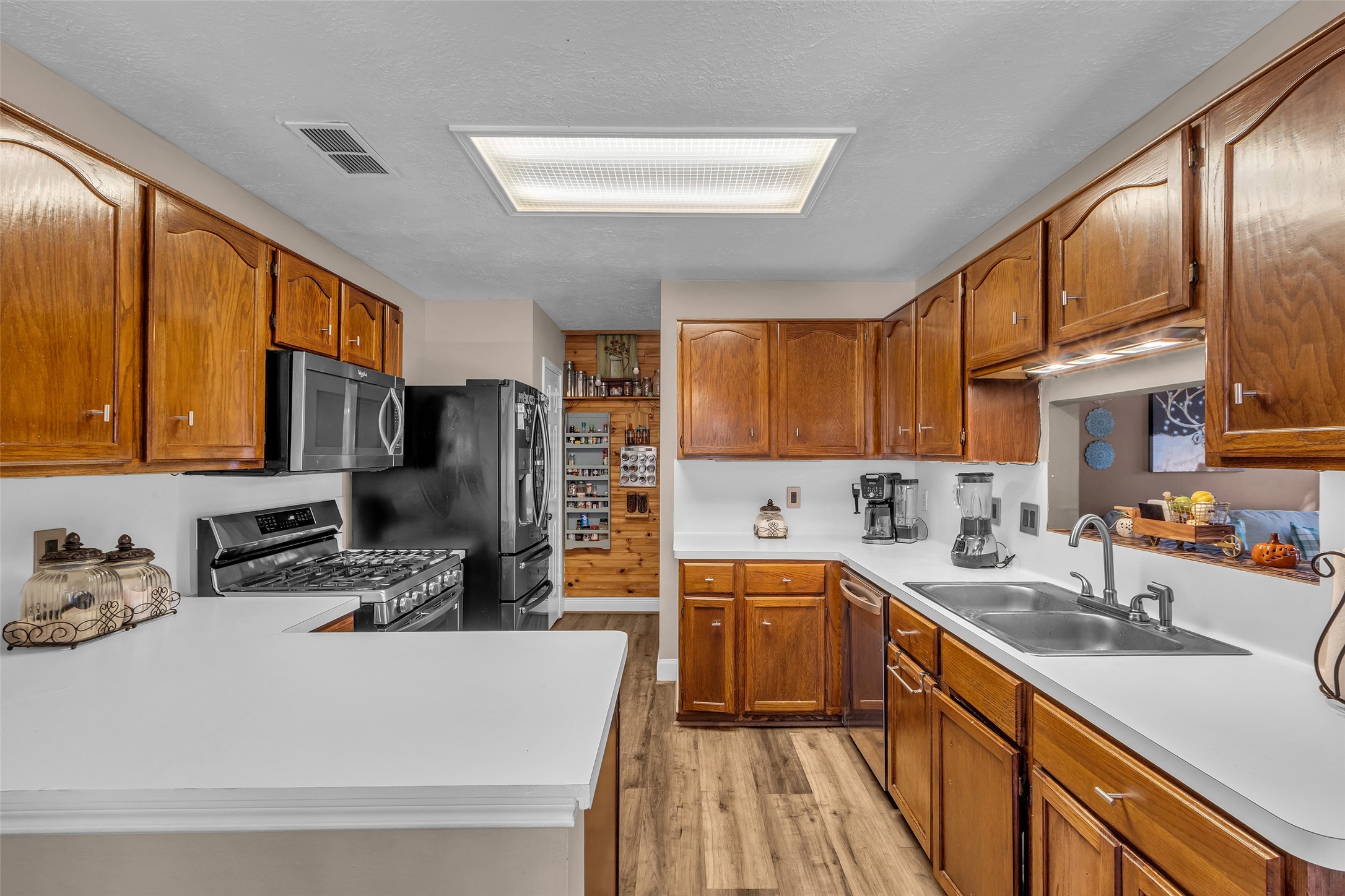 21303 Deerhaven Drive Spring, TX 77388 - Photo 9 of 24 a kitchen with stainless steel appliances a sink a stove a refrigerator cabinets and a large window