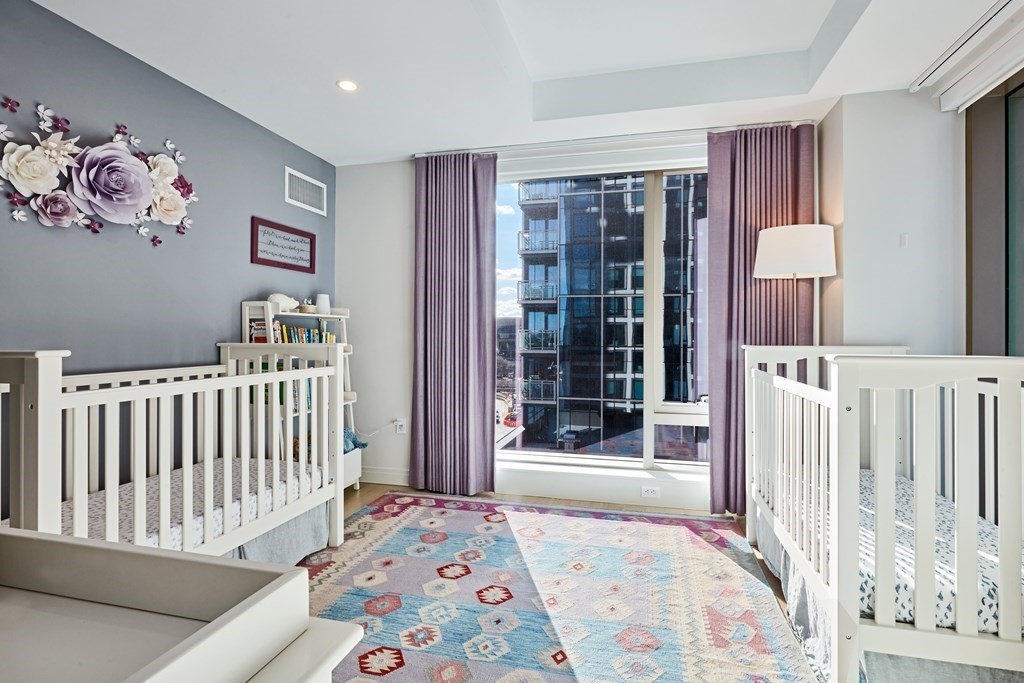 133 Seaport Boulevard, Unit 823 Boston, MA 02210 - Photo 11 of 30 a bedroom with furniture and baby crib