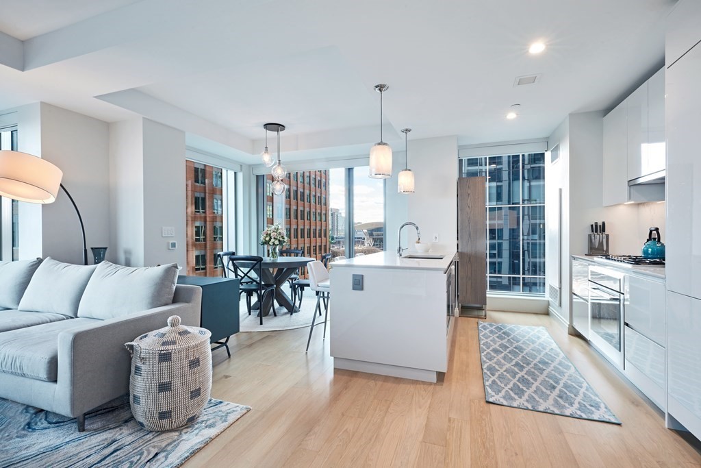 133 Seaport Boulevard, Unit 823 Boston, MA 02210 - Photo 2 of 30 a living room with furniture a large window and wooden floor