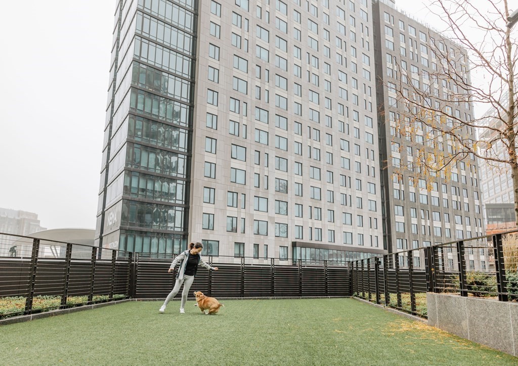 133 Seaport Boulevard, Unit 823 Boston, MA 02210 - Photo 24 of 30 a man sitting on a bench in front of a building