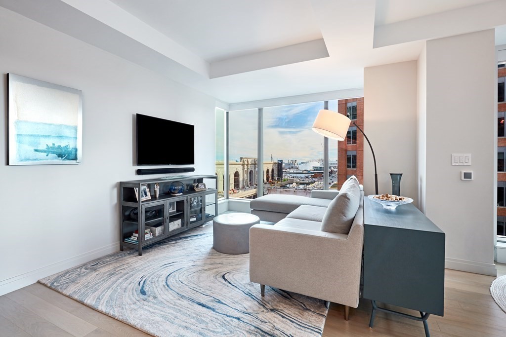 133 Seaport Boulevard, Unit 823 Boston, MA 02210 - Photo 6 of 30 a living room with furniture and a flat screen tv
