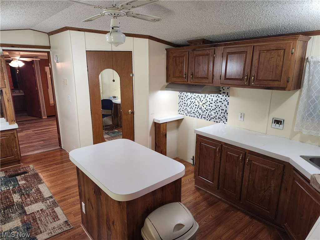 3895 Middletown Road East Youngstown, OH 44514 - Photo 13 of 28 Kitchen featuring ceiling fan, a textured ceiling, dark hardwood / wood-style flooring, and a kitchen island