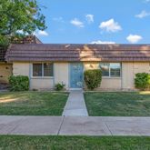 a front view of a house with a yard and potted plants