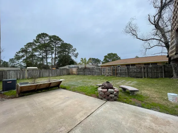 a backyard of a house with barbeque oven and outdoor seating