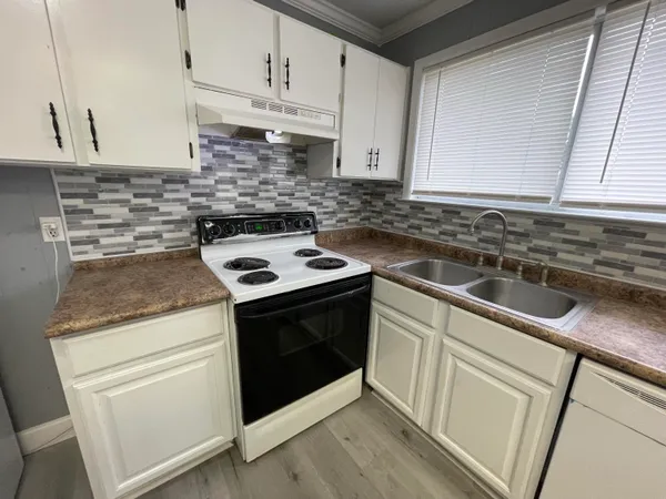 a kitchen with stainless steel appliances granite countertop a sink stove and cabinets