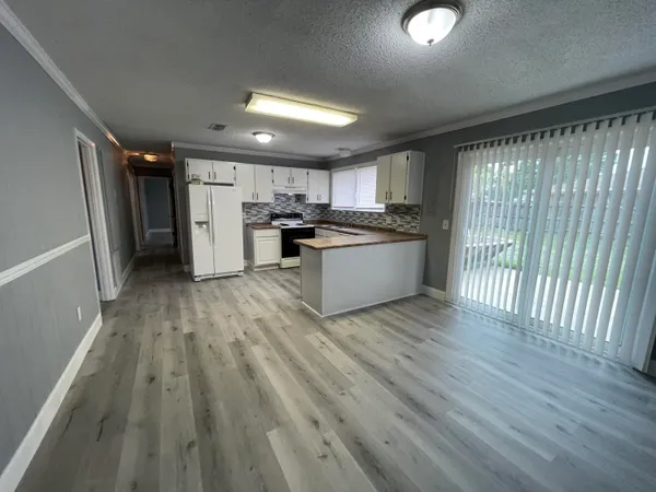 a view of a kitchen with wooden floor and stainless steel appliances