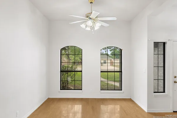 an empty room with windows and chandelier