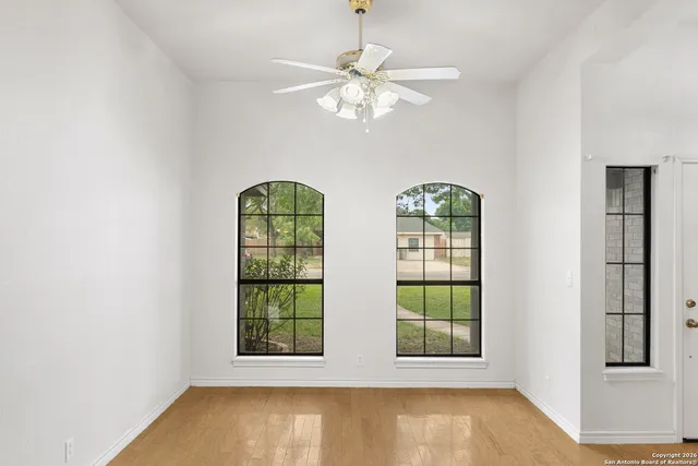 an empty room with windows and chandelier