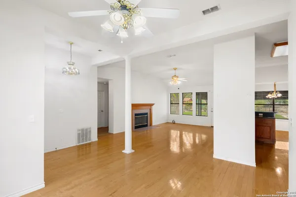 a view of a livingroom with wooden floor and a ceiling fan