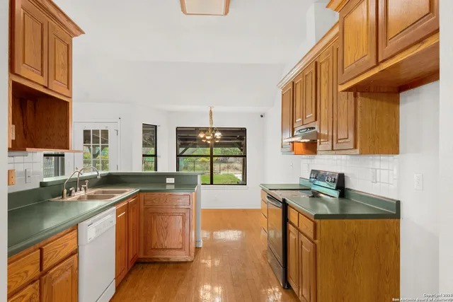a kitchen with stainless steel appliances granite countertop a sink stove and cabinets