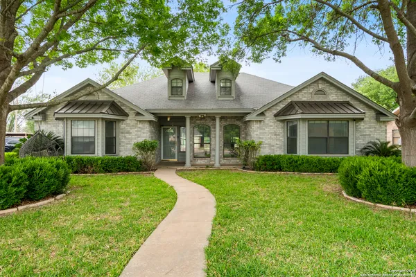 a front view of a house with yard and green space