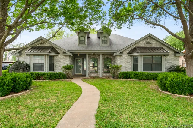 a front view of a house with yard and green space