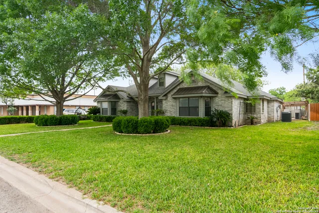 a front view of a house with a yard and trees