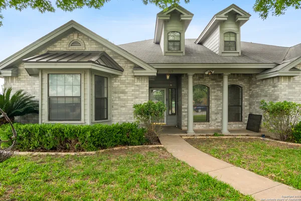 a view of a brick house with a large windows and plants