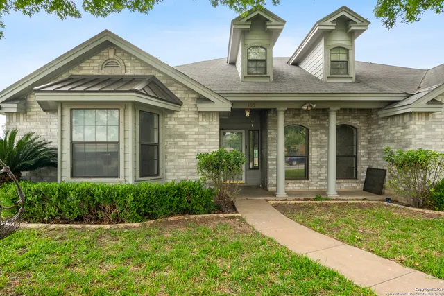 a view of a brick house with a large windows and plants