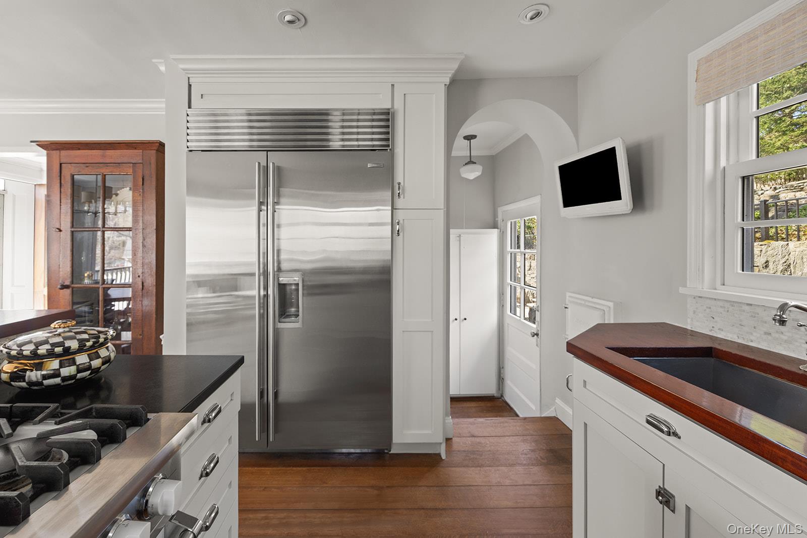 147 Valley Stream Road East Larchmont, NY 10538 - Photo 7 of 37 a kitchen with stainless steel appliances granite countertop a refrigerator a stove and a sink with wooden floor