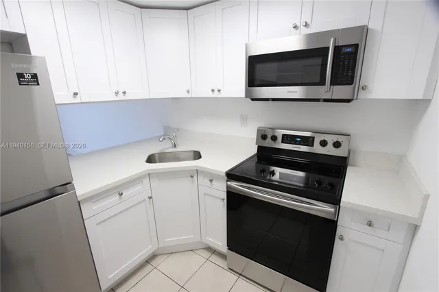 a kitchen with appliances a refrigerator and a sink