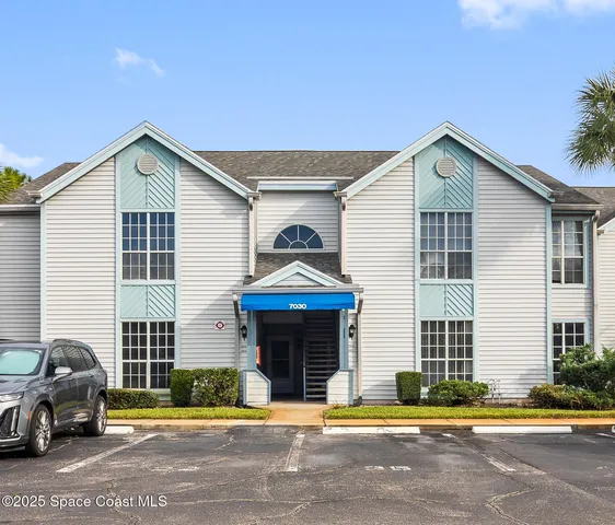 a view of a house with a patio and a yard