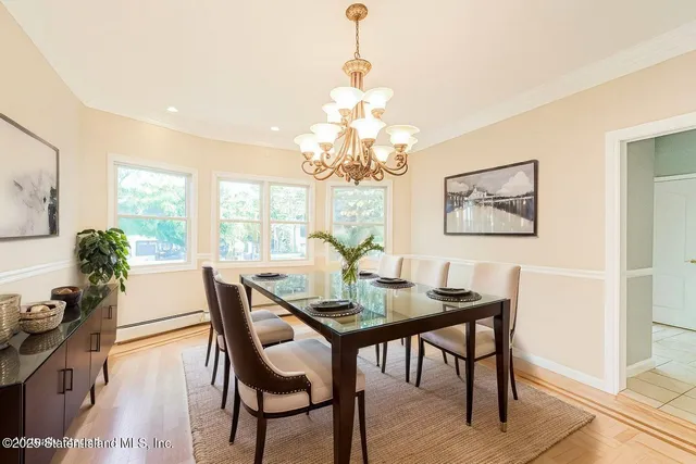 a dining room with furniture a chandelier and wooden floor