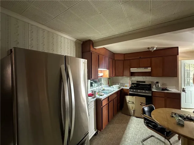 a kitchen with stainless steel appliances granite countertop a refrigerator stove and sink