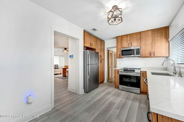 a kitchen with granite countertop a refrigerator stove and sink