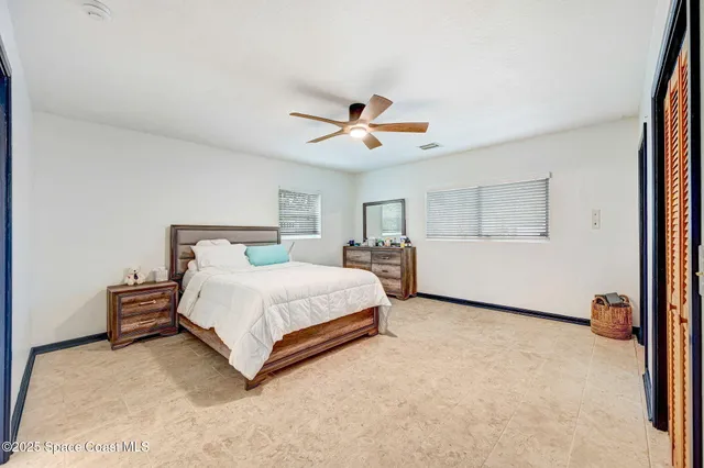 a bedroom with a bed and a ceiling fan