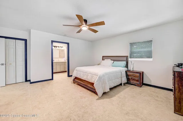a spacious bedroom with a bed and a chandelier