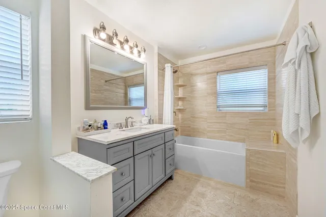 a bathroom with a tub sink and mirror