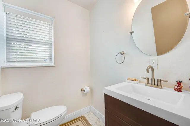 a bathroom with a sink a toilet and mirror