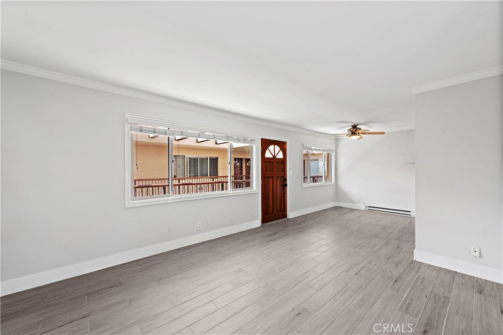 2037 South Coast Highway, Unit 11 Laguna Beach, CA 92651 - Photo 14 of 32 a view of an empty room with a window and wooden floor