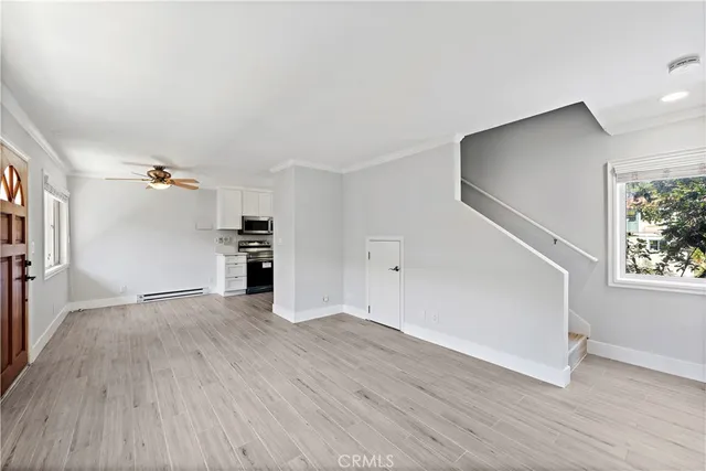 a view of empty room with wooden floor and windows