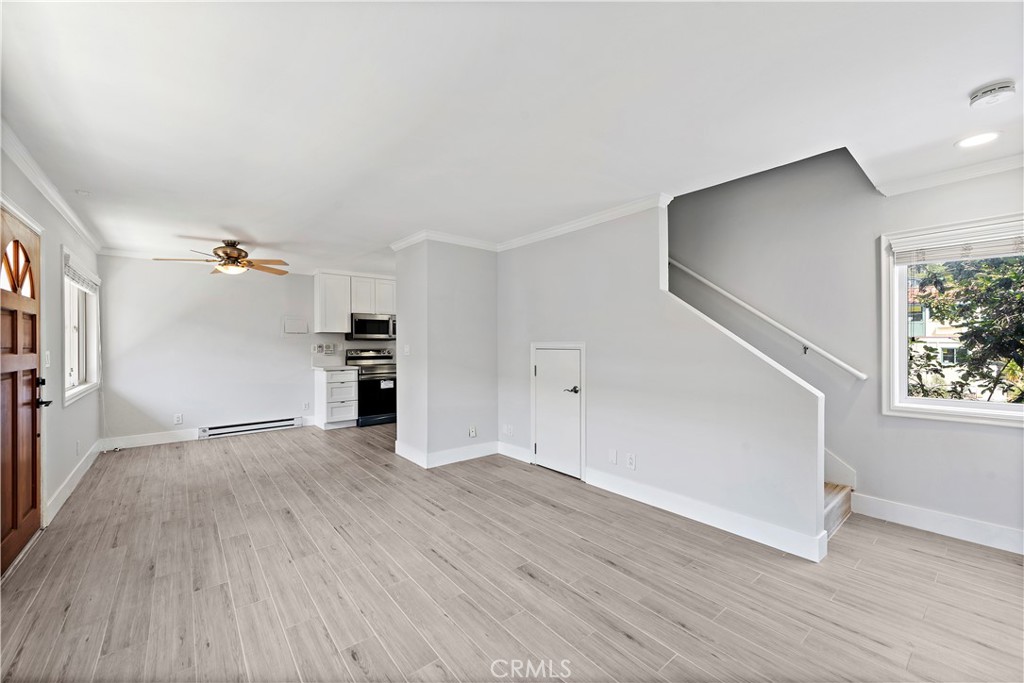 2037 South Coast Highway, Unit 11 Laguna Beach, CA 92651 - Photo 15 of 32 an empty room with wooden floor and windows