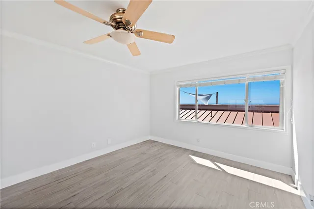 a view of an empty room and window with wooden floor