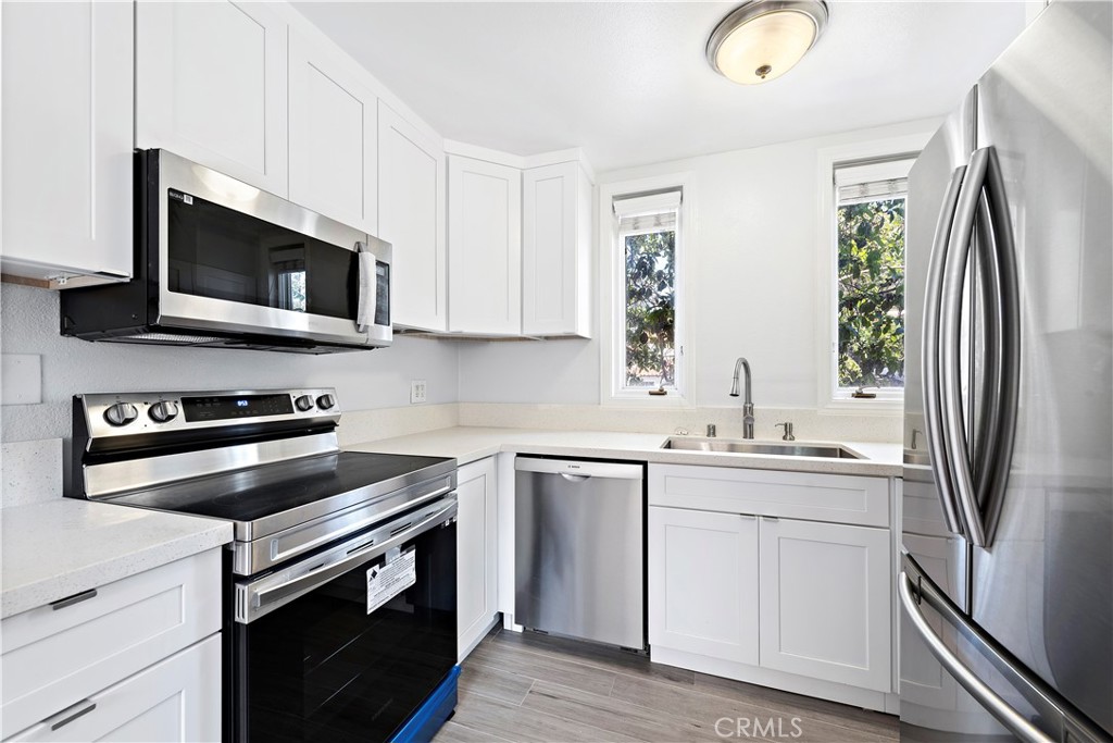 2037 South Coast Highway, Unit 11 Laguna Beach, CA 92651 - Photo 3 of 32 a kitchen with a sink stove and microwave