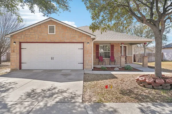 a view of a house with a yard and large tree