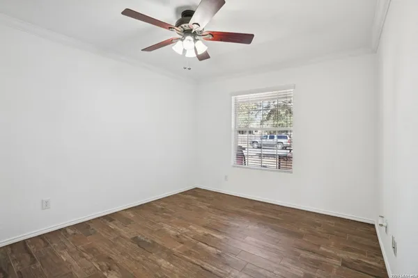 an empty room with a window and a fan