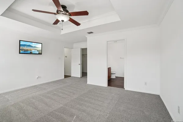 an empty room with closet and a ceiling fan
