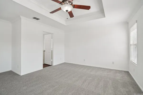 an empty room with windows and fan