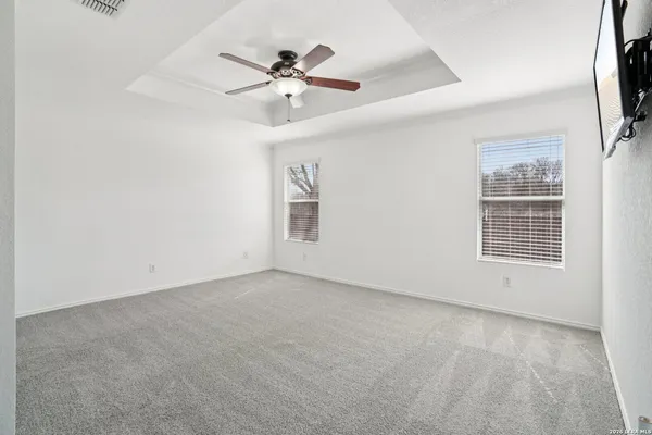 an empty room with windows and fan