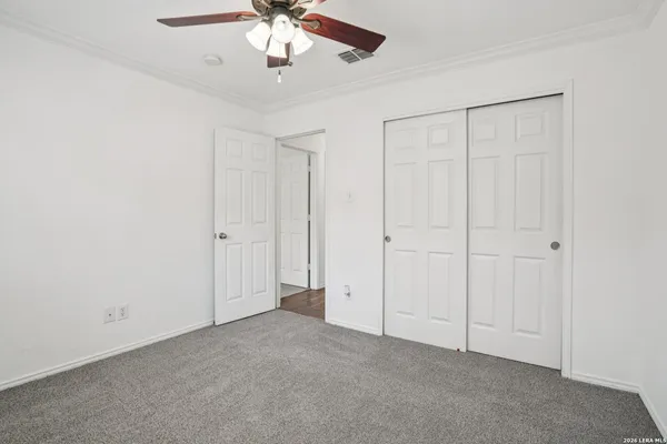 an empty room with a chandelier fan