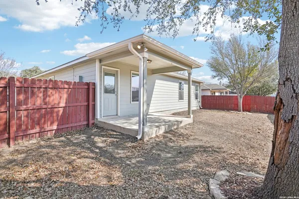 a view of a house with a yard and wooden fence