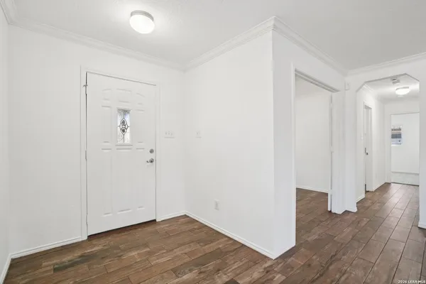 an empty room with wooden floor & closet area