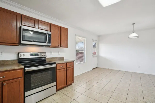 a kitchen with granite countertop a stove a microwave and cabinets