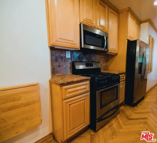 a kitchen with stainless steel appliances granite countertop a stove microwave and refrigerator