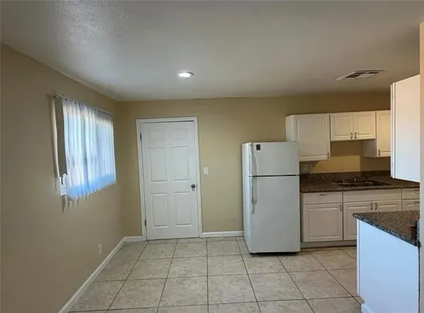 a kitchen with a refrigerator a stove top oven and cabinets