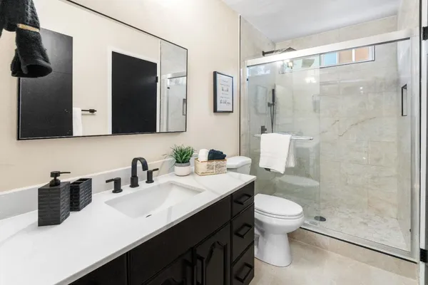 a bathroom with a sink a toilet and shower