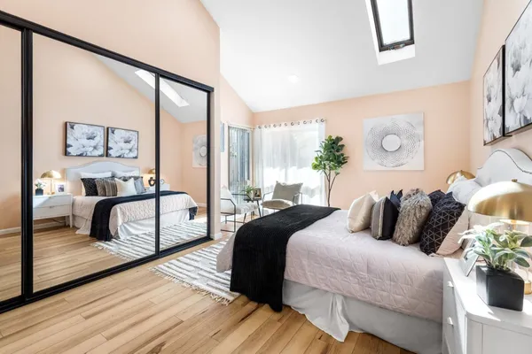 a bedroom with a bed and a large mirror on the dresser